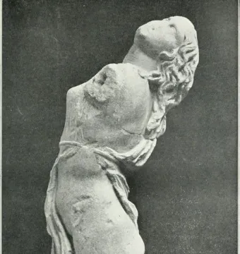 Dancing Maenad sculpture shown as a pale stone female torso arching backward, with wavy hair and draped fabric around the hips.