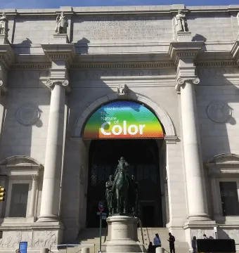 Theodore Roosevelt Equestrian Statue beneath a banner for The Nature of Color at a museum entrance.