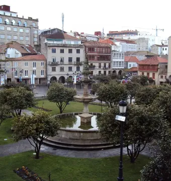 Herrería Fountain in a tree-lined park with surrounding buildings