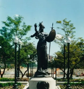 Russell Alger Memorial Fountain with a helmeted female figure holding a shield and sword atop a stone pedestal in a fountain basin.
