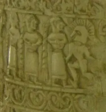 Detail of the Situla of the Pania showing a carved relief band with human figures, including a figure in a crested helmet.