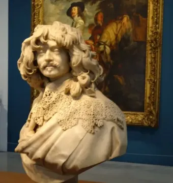 Marble bust of Thomas Baker with curly hair, mustache, and a pointed beard.