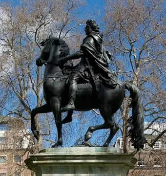 William III equestrian statue on a stone pedestal in St James\'s Square, with bare branches and buildings behind it.