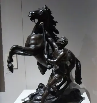 Marly Horses bronze sculpture of a rearing horse and a muscular man wrestling it with a staff.