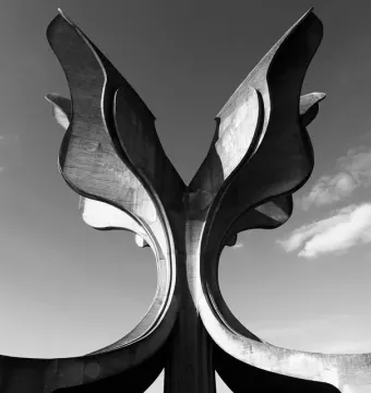 Stone Flower, a large concrete sculpture with curved petal-like forms rising against a cloudy sky.