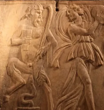 Relief on the Sarcophagus of the Triumph of Bacchus showing a satyr with a pan flute facing a dancing bacchante with a tambourine.