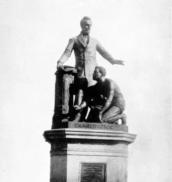 Emancipation Memorial showing a standing man in a suit beside a kneeling man with broken shackles.
