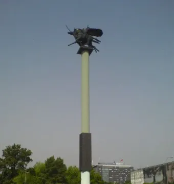 Polish Cavalry Monument on a tall pillar above a grassy mound, with dark horse and rider figures at the top.