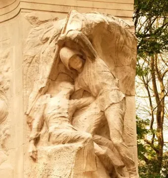 High relief of two figures in the Monument to the Belgian Pioneers in Congo, with Dutch and French inscriptions on the base.
