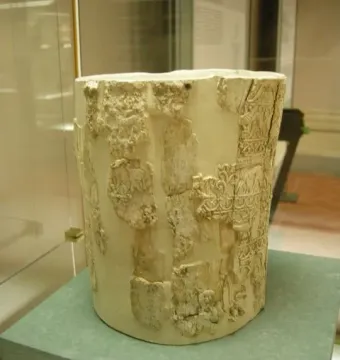 Situla of the Pania with a cream-colored cylindrical body and carved relief decoration