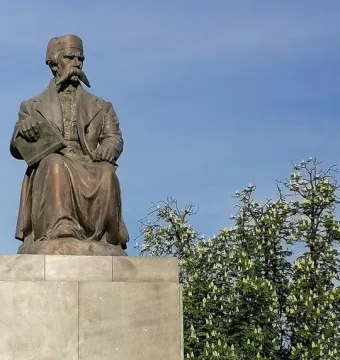Vuk Karadžić Monument, a bronze seated statue of a man holding an open book on a stone pedestal with Cyrillic inscriptions.