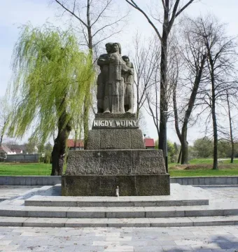 The War Never Again monument in Żabikowo shows three embraced figures on a stepped pedestal with the inscription \