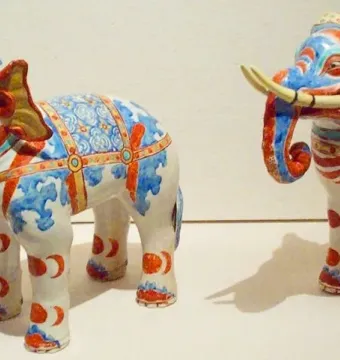 Pair of Kakiemon elephants decorated with blue and red patterns and prominent tusks.
