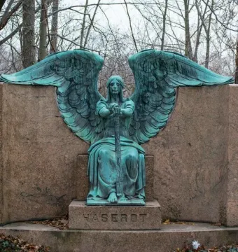 Haserot Angel bronze sculpture with outstretched wings and inverted torch atop a granite monument