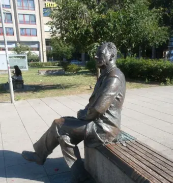 Willy Brandt memorial bronze statue seated on a wooden bench outdoors