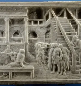 The Feast of Herod marble relief with figures gathered around a banquet table, a dancing woman in the center, and arched colonnades behind them.