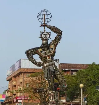 La Nouvelle Liberté sculpture made from metal scraps and mechanical parts, topped with a raised globe on a pedestal in Douala.