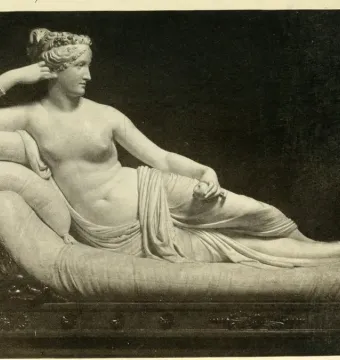 Venus Victrix, a reclining white marble statue of a partially nude woman on an ornate daybed, holding a small round object.