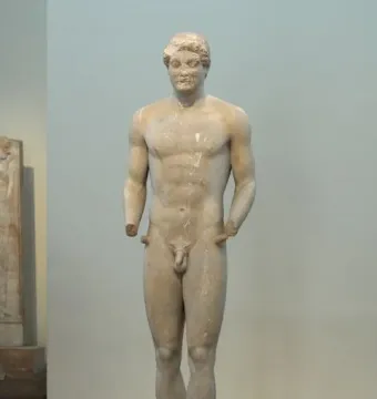 Aristodikos Kouros, a nude marble male statue standing upright on a base with missing forearms.