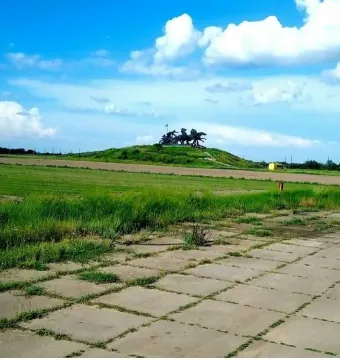 Legendary Tachanka monument on a grassy hill under a blue sky with clouds