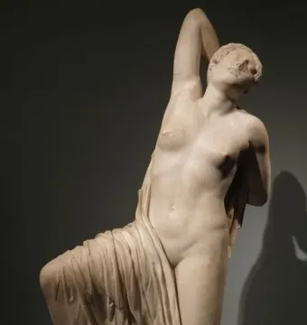 The Niobid from the Gardens of Sallust, a pale marble sculpture of a kneeling female figure with one arm raised behind her head.