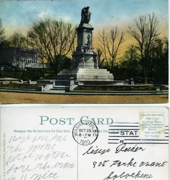 Peace Monument with a tall stone pedestal, draped figure on top, and smaller sculpted figures below, surrounded by a circular planter and steps.