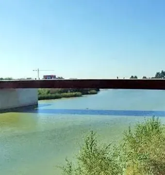 Aerial view of the Puente de Miraflores spanning a wide greenish river