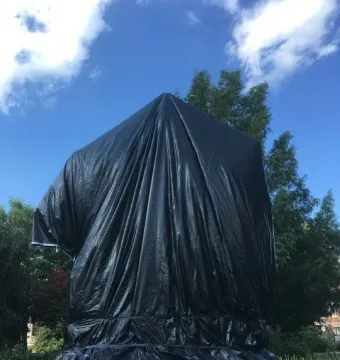 Robert E. Lee Monument covered in black plastic sheeting in a park