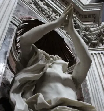 Bernini\'s Daniel and the Lion marble sculpture with raised arms in an ornate niche