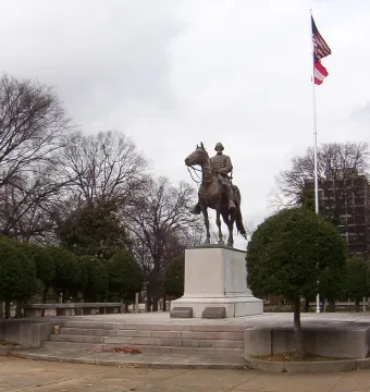 Nathan Bedford Forrest Monument showing a bronze equestrian statue on a multi-tiered pedestal in a park setting.