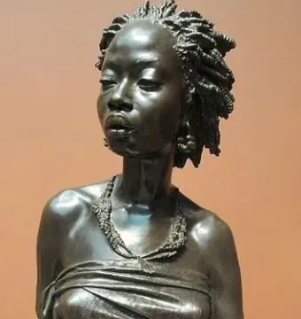 The Nubian Woman bronze bust with braided hair, earrings, and a draped garment.