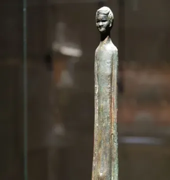Detail of Ombra della sera, showing a slender bronze figure with an elongated body and serene carved head.
