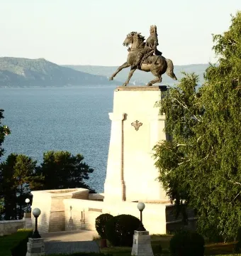 Tatishchev Monument showing a rider on a rearing horse atop a tall stone pedestal by the water.