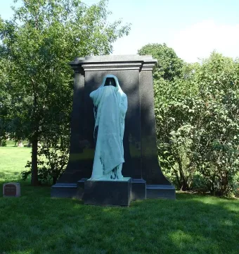 Eternal Silence sculpture with a hooded, green-patinated figure standing before a tall stone monument.