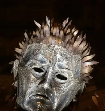Close-up of the Knife Angel sculpture’s metallic head with hollow eyes and blade-like spikes forming the hair.