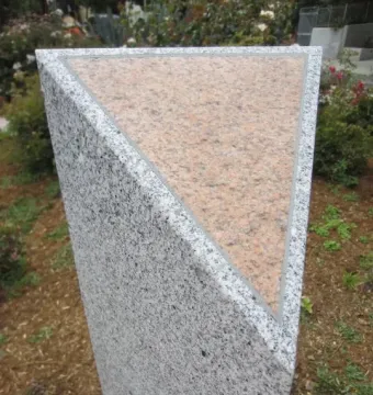 A grey granite pillar with a pink-speckled triangular top at Pink Triangle Park.