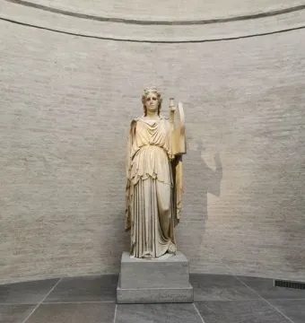 Apollo Barberini statue standing on a plinth in the Glyptothek museum, holding part of a lyre-like object