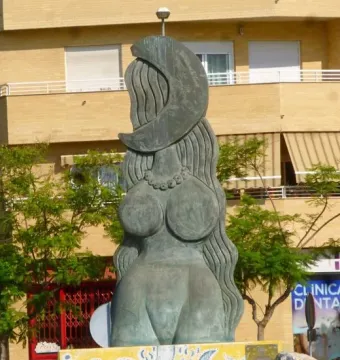 Dona Lluna bronze sculpture with a female torso, long wavy hair-like forms, and a crescent moon on top.