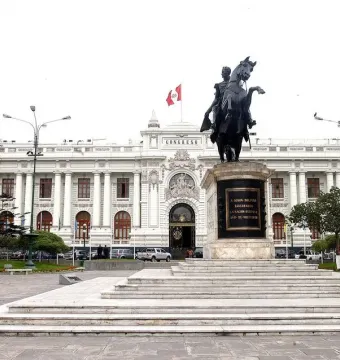 Equestrian statue of Simón Bolívar on a rearing horse in a paved plaza, with the Congress building in the background.