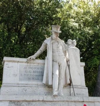 Monument to Giuseppe Gioachino Belli showing a marble statue of a man in a top hat and long coat beside two draped female figures.
