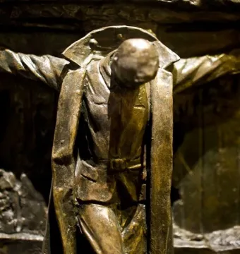 Canada\'s Golgotha bronze sculpture showing a bowed soldier with outstretched arms against a textured wall