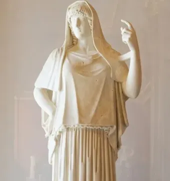 Giustiniani Hestia, a white marble statue of a veiled woman in flowing drapery with one hand raised.