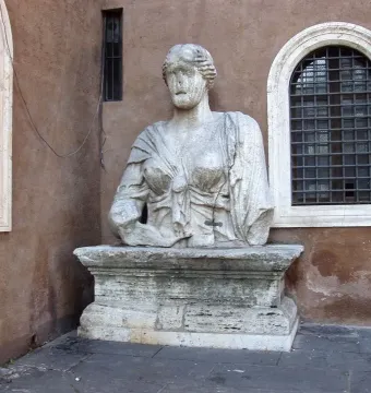 Madama Lucrezia stone bust mounted on a pedestal beside barred windows.