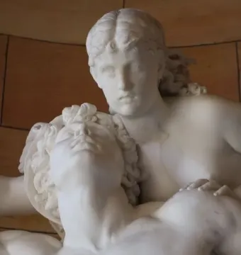 Mercury and Psyche carved in white stone, shown in close-up with one figure looking upward and the other leaning over his shoulder.
