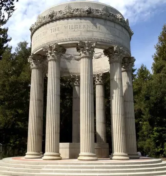 Pulgas Water Temple stone monument with fluted columns and a domed roof surrounded by trees.