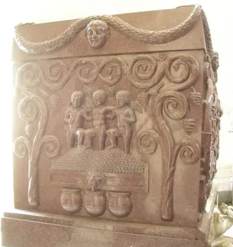 Sarcophagus of Constantina with relief carvings of figures stomping grapes in a vat, framed by grapevines and a garland above.