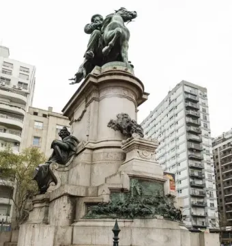 Monument to Giuseppe Garibaldi with a bronze equestrian statue atop a tall stone base and relief panels.