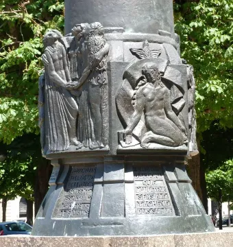 Lower section of the Mickiewicz monument showing bronze relief panels and inscriptions on the socle.