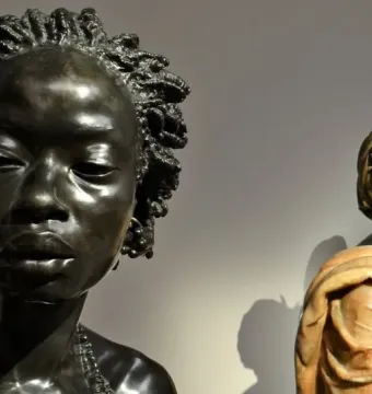 Bust of Woman from the French Colonies with textured hair, shown close up with a second draped figure in the background.