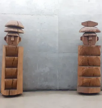 Chemamull wooden figures standing against a gray wall.